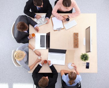 İş adamları iş toplantısında, ofiste oturup tartışıyorlar.