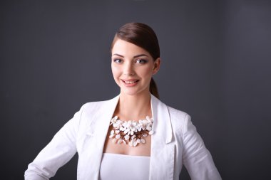 Boncuklar, gri arka plan üzerinde duran genç kadın portresi