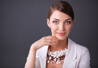 Boncuklar, gri arka plan üzerinde duran genç kadın portresi