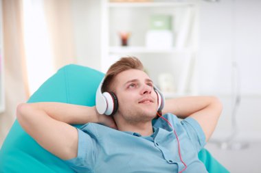 Adam evde kulaklık ile müzik dinleme