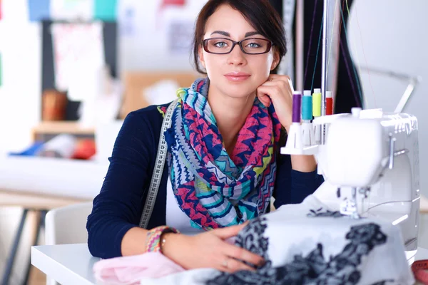 Mujer joven cosiendo sentado en su lugar de trabajo — Foto de Stock