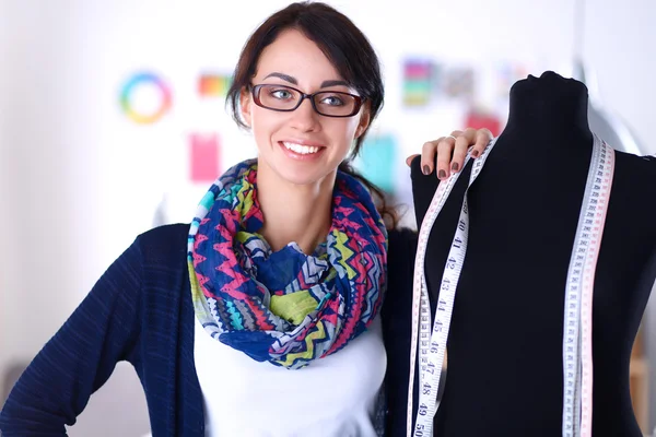 Diseñador de moda sonriente de pie cerca del maniquí en la oficina —  Fotos de Stock