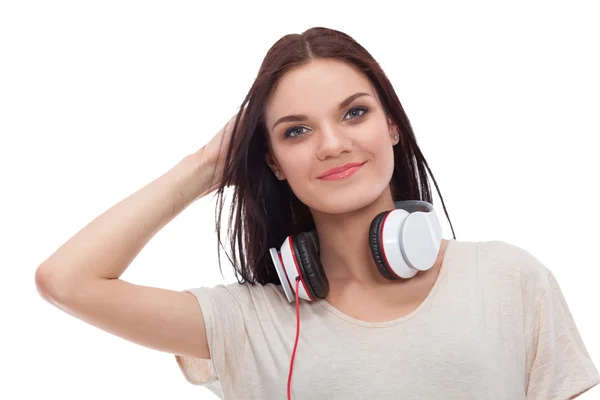 Smiling girl with headphones sitting on the floor near wall — Stock Photo, Image