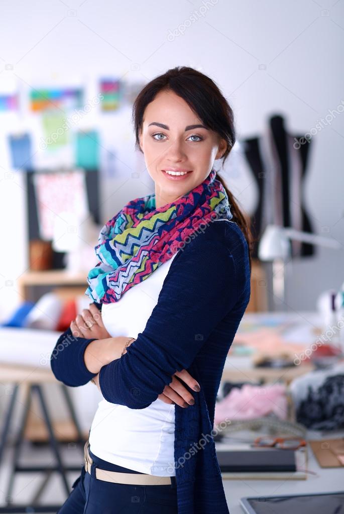 Beautiful fashion designer standing in studio