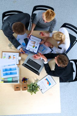 İş adamları iş toplantısında, ofiste oturup tartışıyorlar.