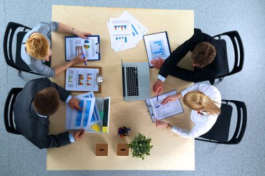 İş adamları iş toplantısında, ofiste oturup tartışıyorlar.