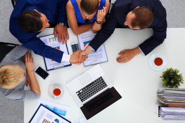 İş adamları iş toplantısında, ofiste oturup tartışıyorlar.