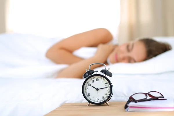 En ung kvinna stänger av väckarklockan på morgonen. — Stockfoto