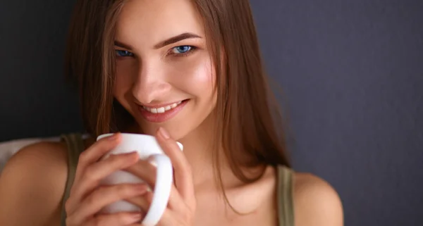 Beautiful woman sitting on the floor and drinking — Stock Photo, Image