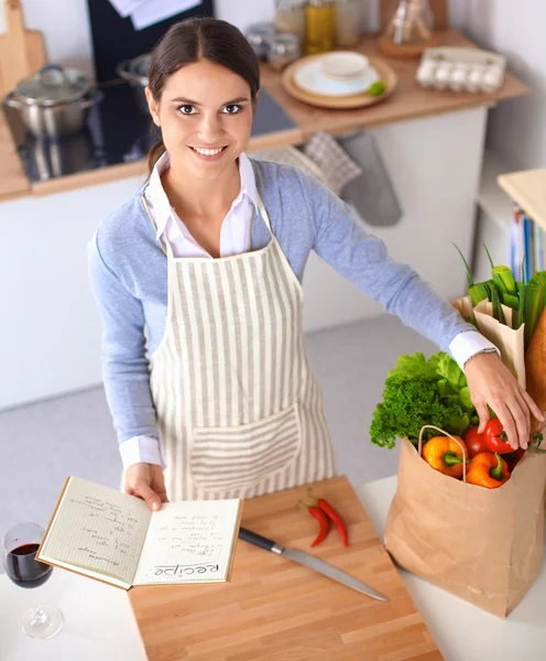 Frau macht gesunde Lebensmittel lächelnd in Küche — Stockfoto