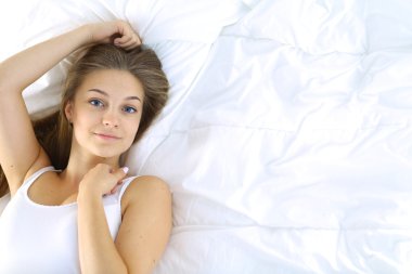 Yatakta rahat ve mutlu bir şekilde yatan güzel bir genç kadın.
