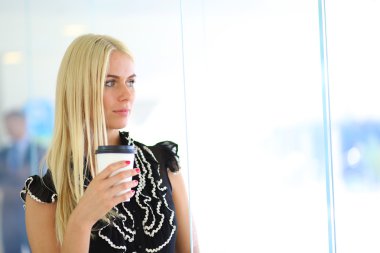 Ofiste bir fincan kahve ayakta tutan işkadını