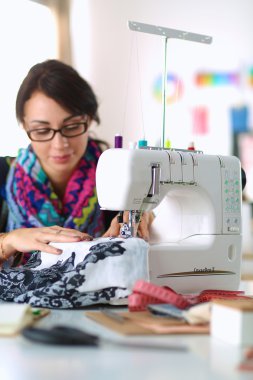 Çalışırken dikiş diken genç bir kadın.