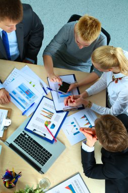 İş adamları iş toplantısında, ofiste oturup tartışıyorlar.