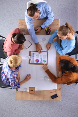 İş adamları iş toplantısında, ofiste oturup tartışıyorlar.