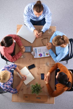 İş adamları iş toplantısında, ofiste oturup tartışıyorlar.