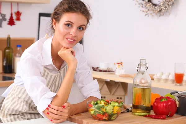 Mujer joven sonriente de pie en la cocina —  Fotos de Stock