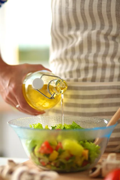 Young woman mixing fresh salad standing near desk — Stock Photo, Image