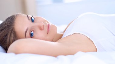 Yatakta rahat ve mutlu bir şekilde yatan güzel bir genç kadın.