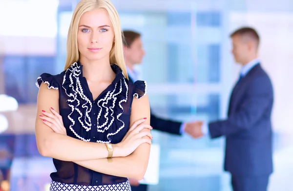 Zakenvrouw permanent op voorgrond in office — Stockfoto