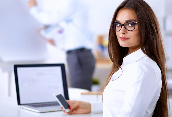 Empresária atraente sentada na mesa no escritório — Fotografia de Stock