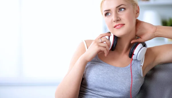 Joven hermosa mujer en casa sentada en el sofá y escuchando música —  Fotos de Stock