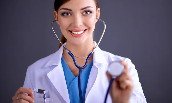 Médica com estetoscópio, isolada sobre fundo cinzento — Fotografia de Stock