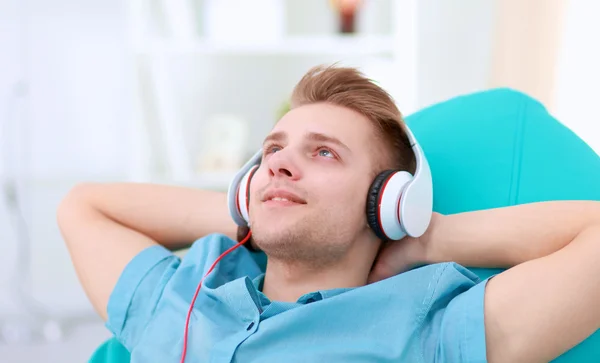 Uomo che ascolta musica con le cuffie a casa — Foto Stock