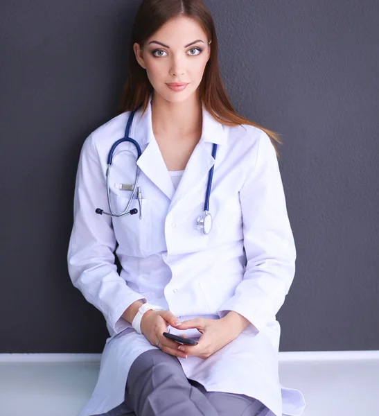 Young woman doctor sitting with your phone — Stock Photo, Image