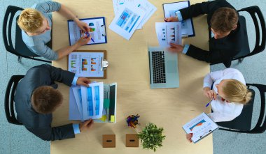 İş adamları iş toplantısında, ofiste oturup tartışıyorlar.