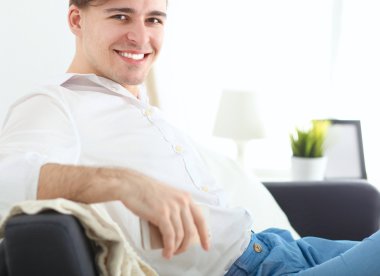 Genç işadamı ofiste çalışıyor, masada oturuyor.