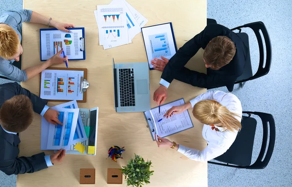 İş adamları iş toplantısında, ofiste oturup tartışıyorlar.