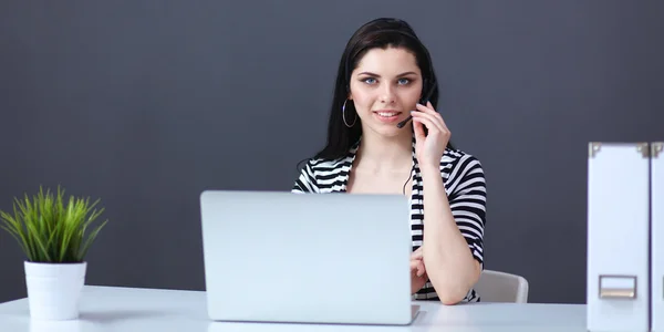 Piękna kobieta biznesu pracuje przy biurku ze słuchawkami i laptopem — Zdjęcie stockowe