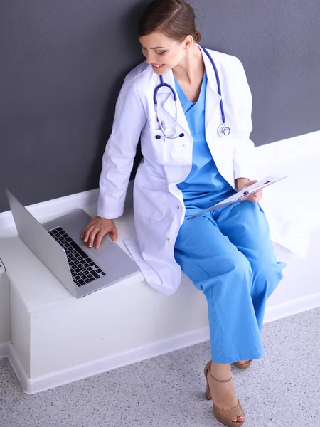 Female doctor working sitting on gray  background — Stock Photo, Image