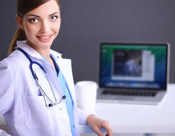 Kvinna läkare som arbetar sitter på grå bakgrund — Stockfoto