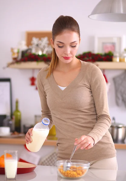 Leende attraktiv kvinna som äter frukost i köket interiör — Stockfoto