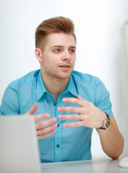 Young businessman working in office, sitting at desk — Stock Photo, Image