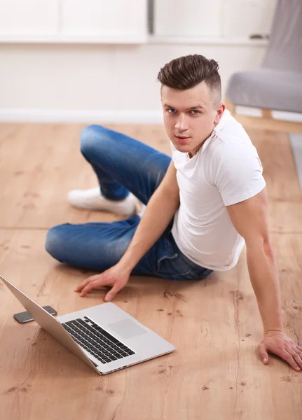 Молодой бизнесмен, работающий в офисе, сидит на полу — стоковое фото
