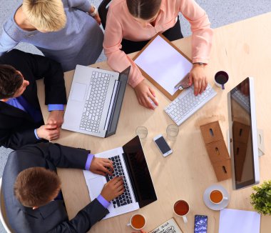 İş adamları iş toplantısında, ofiste oturup tartışıyorlar.