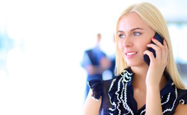 Ofiste cep telefonu kullanan güzel bir iş kadını.