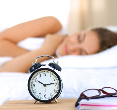 Genç bir kadın sabah alarmını erteliyor.