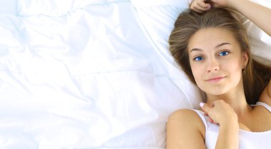 Yatakta rahat ve mutlu bir şekilde yatan güzel bir genç kadın.