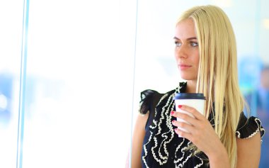 Ofiste bir fincan kahve ayakta tutan işkadını