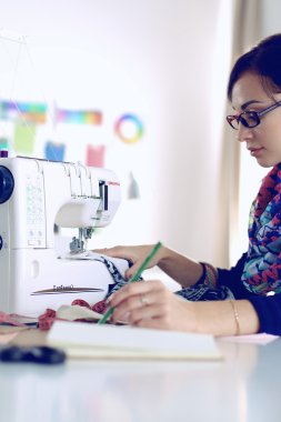 Çalışırken dikiş diken genç bir kadın.