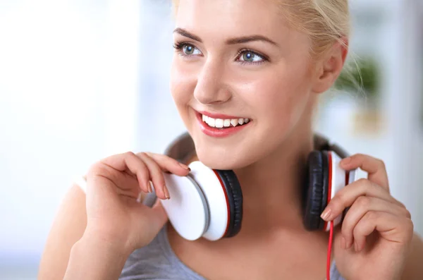 Young beautiful woman at home sitting on sofa and listening music — Stock Photo, Image