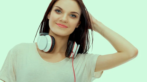 Smiling girl with headphones sitting on the floor near wall — Stock Photo, Image