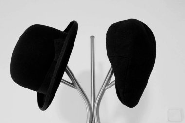 İki eski siyah şapka stantta.