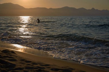 Deniz günbatımının arka planında siluet