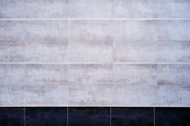 Paslı efektli, eskimiş beyaz fayanslı duvar ve siyah süpürgelik 