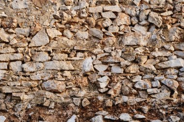 Old traditional limewashed stone wall with peeling plaster, rustic background or texture clipart
